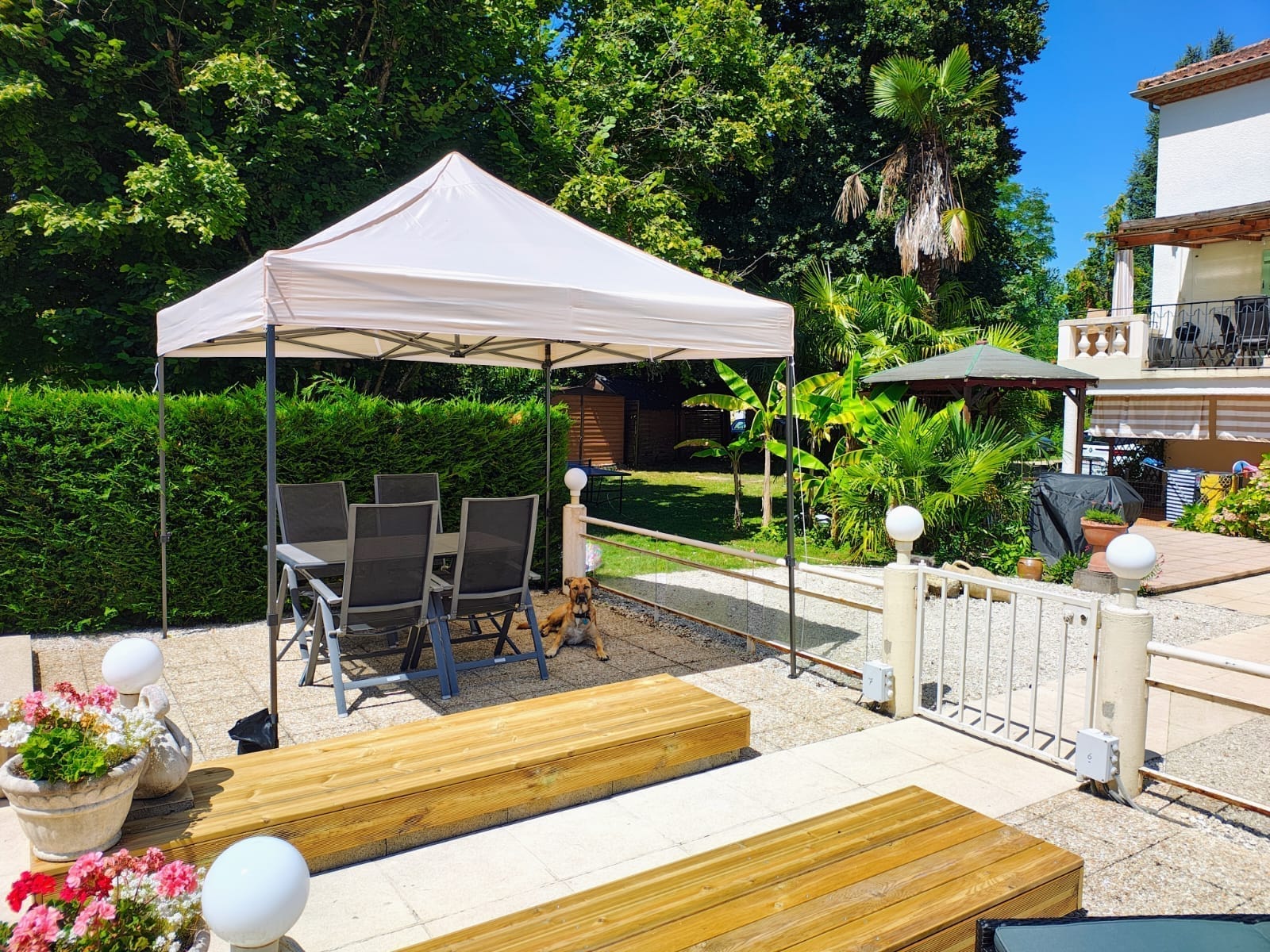 De tuin met paviljoen en zithoek bij het huis.